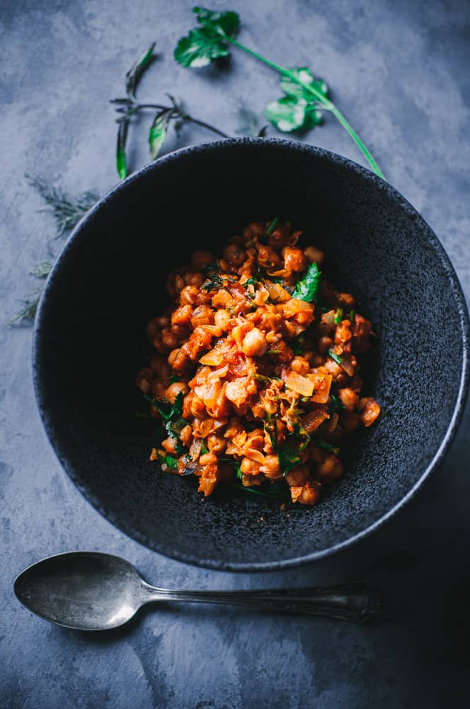 a black bowl filled with moroccan chickpeas