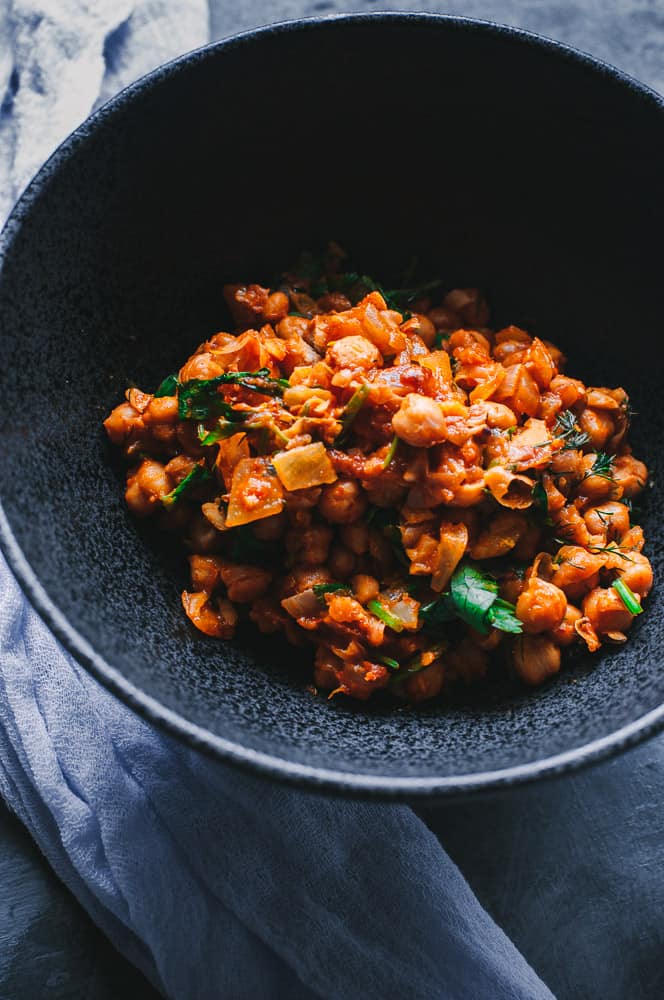 a black bowl filled with moroccan chickpeas