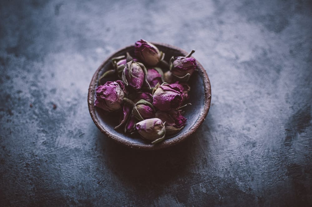 a shallow bowl filled with organic rose buds