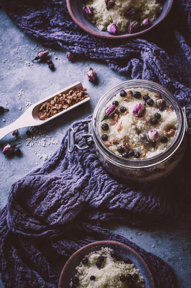 jars and bowls filled with bath salts, juniper berries, rose buds, rosemary oil, hemp oil and grapefruit peels