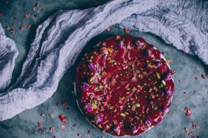 persian love cake with red glaze next to gauzy fabric