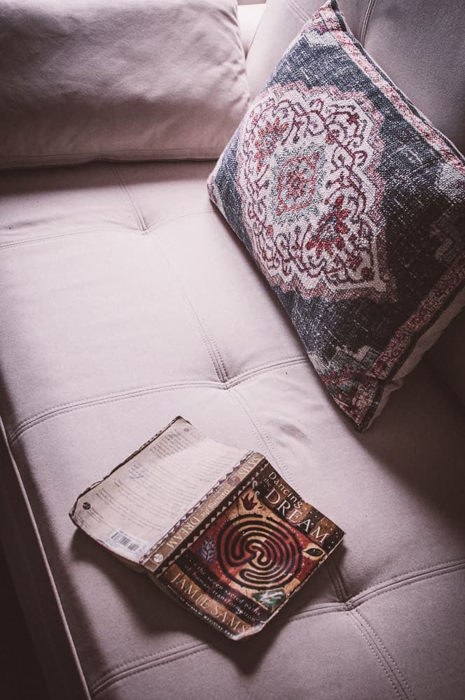 a white organic sofa bed couch with a jamie sams book lying open