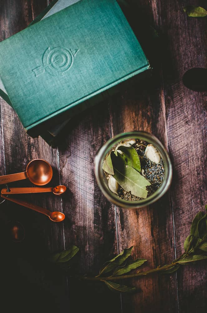 a jar filled with herbs on a dark wooden backdrop