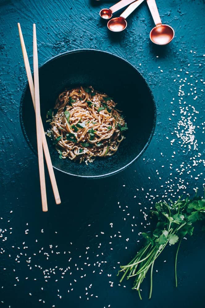 flatlay black bowl sesame noodles chopsticks cilantro