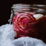 a side shot of a jar filled with pickled red onions