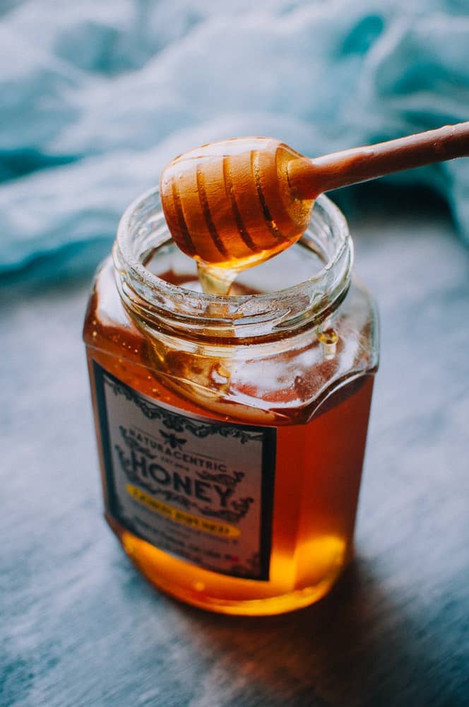 honey spoon dripping lemon honey jar