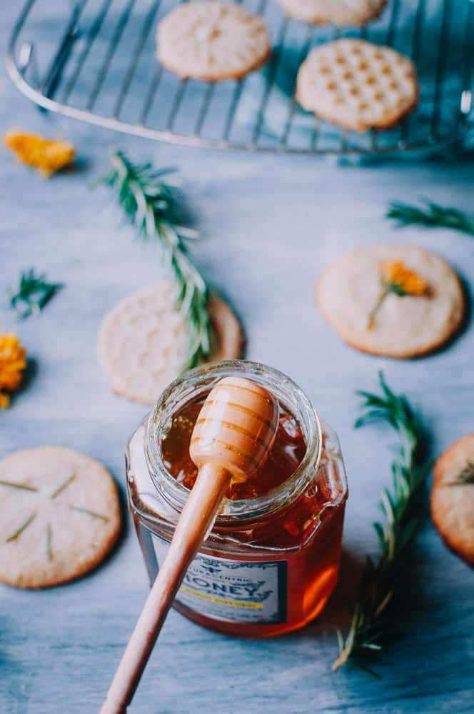 luscious wooden honey spoon dipped in a jar of lemon infused honey