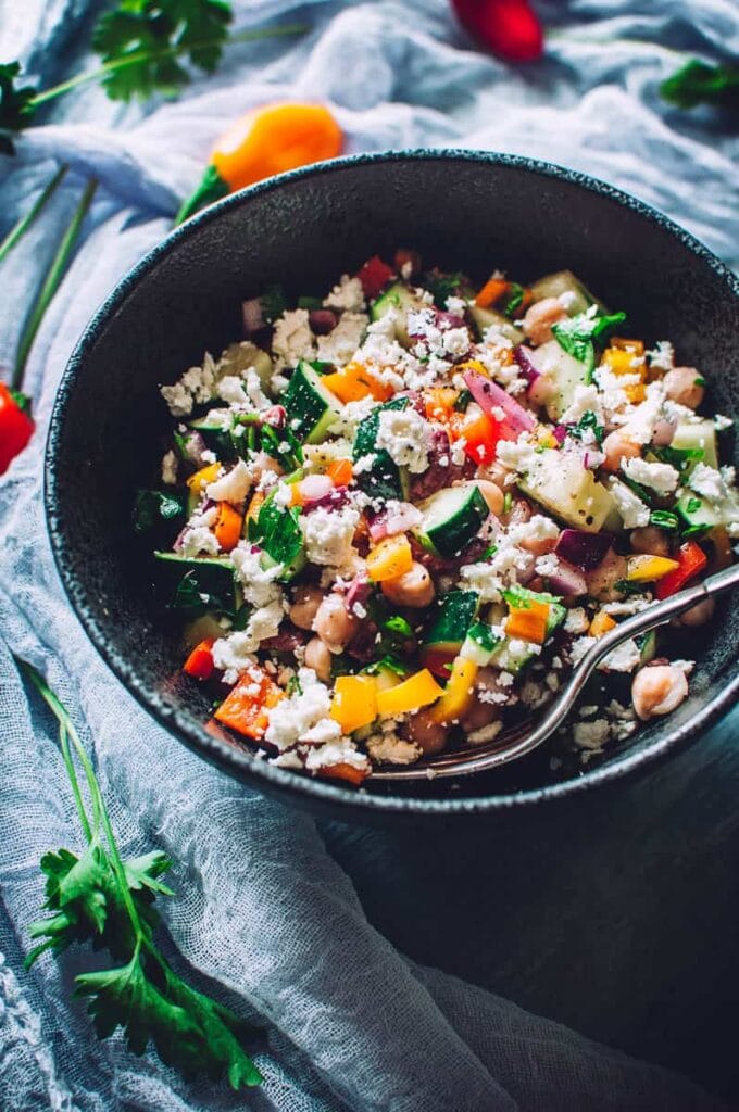 a colorful cucumber salad topped with feta cheese