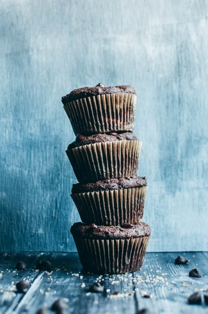 a stack of zucchini muffins against a blue backdrop