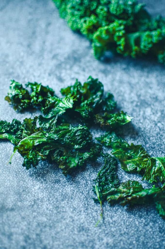 a bunch of kale chips on grey background