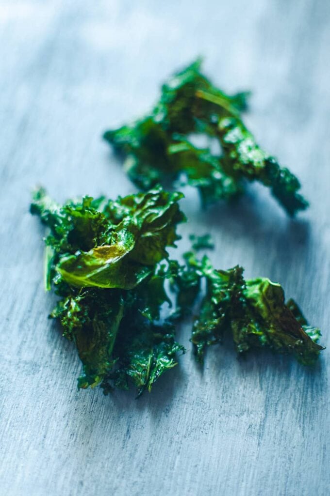 freshly air fired kale chips resting on a table