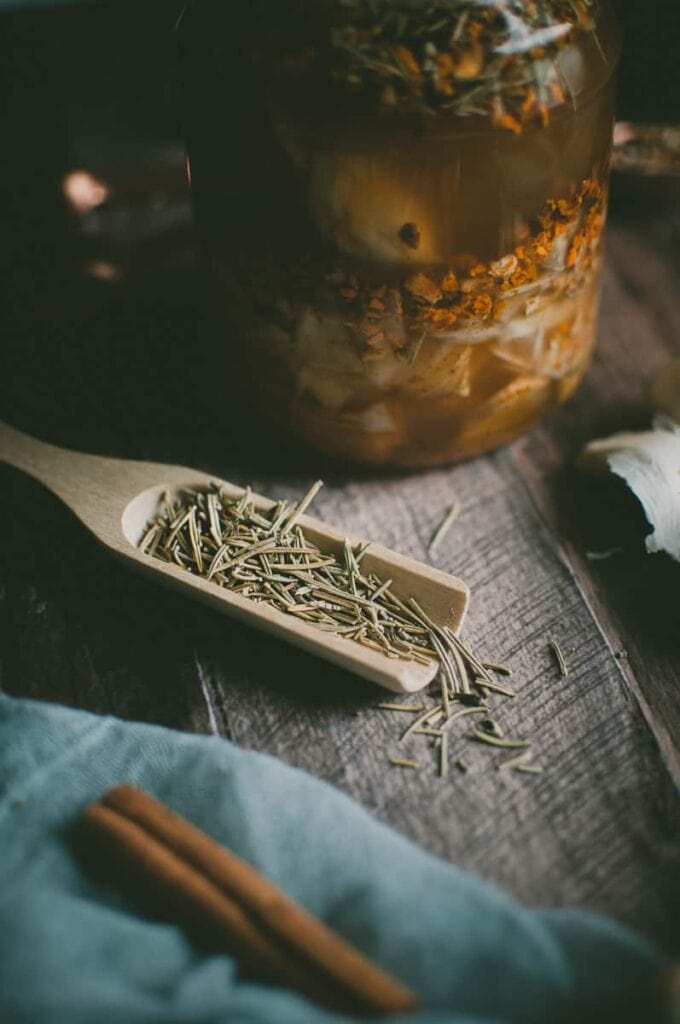 a wooden spoon filled with dried rosemary