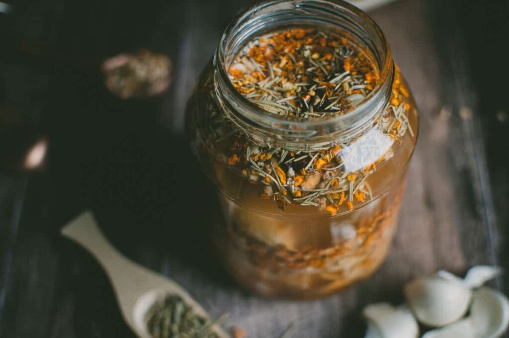 a close up of open jar of fire cider tonic