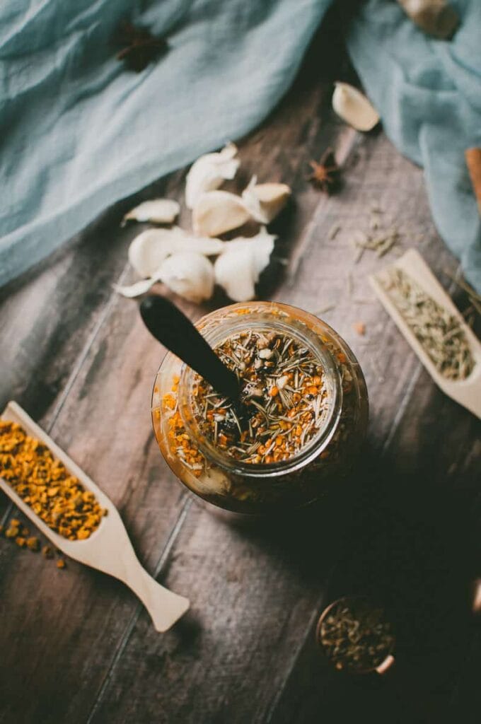 an open jar of fire cider with a wooden spoon stuck in