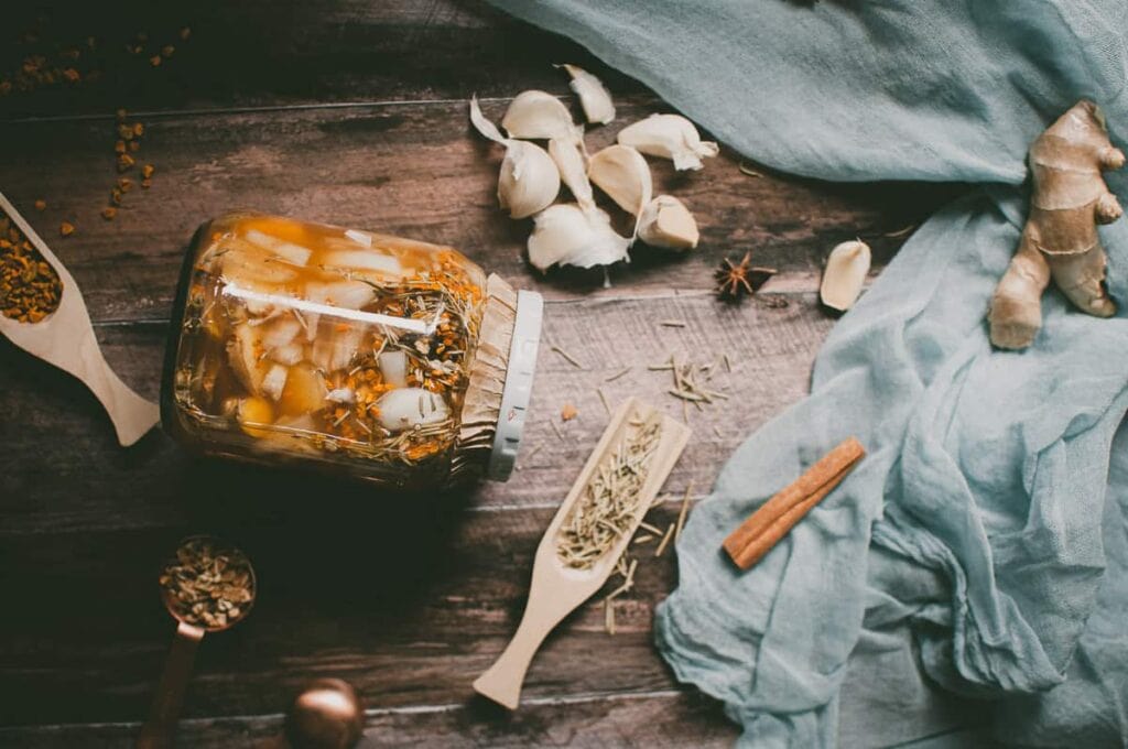 a jar of fire cider on wooden backdrop