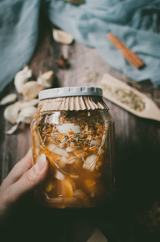 a hand holding a jar of fire tonic