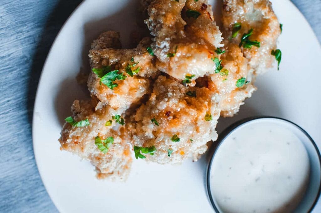 baked cauliflower wings next to a bowl of ranch