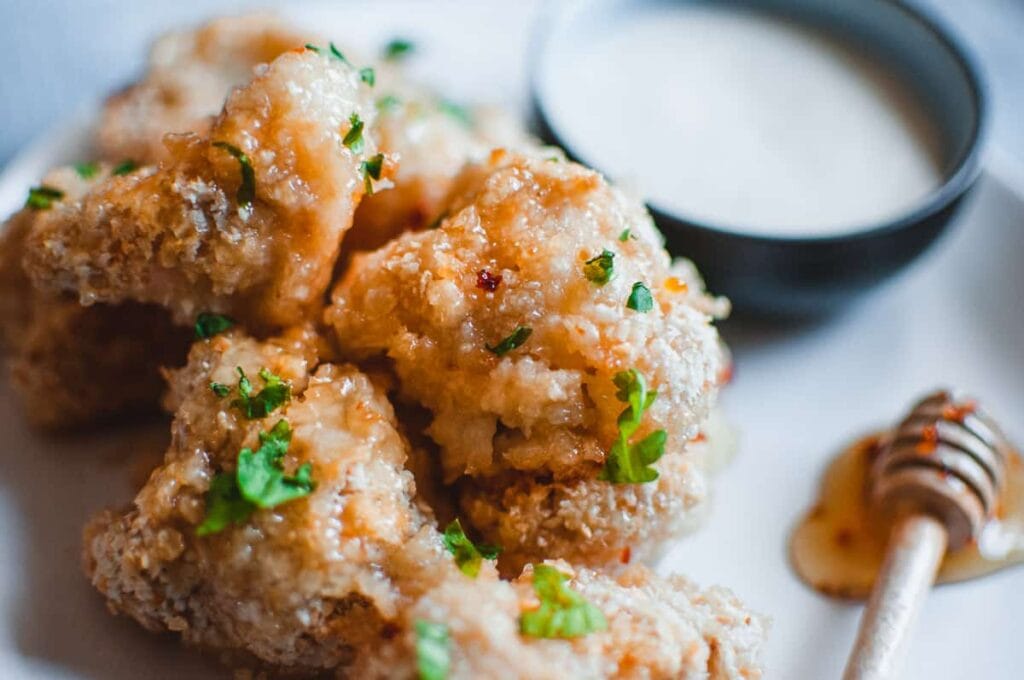 a pile of cauliflower wings drizzled with honey