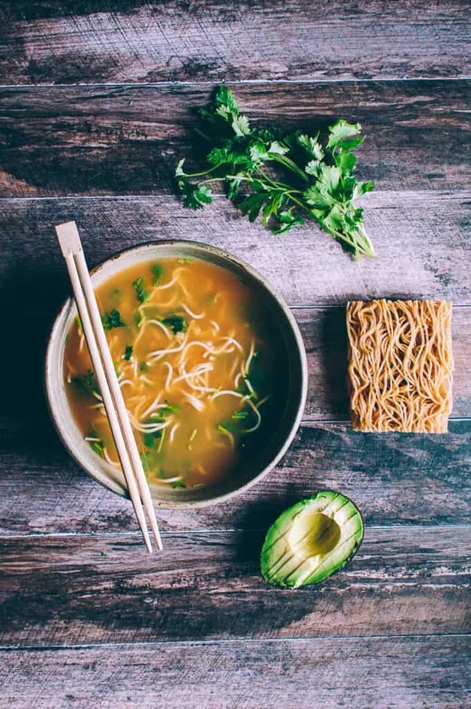 a bowl of pho on a wooden backdrop