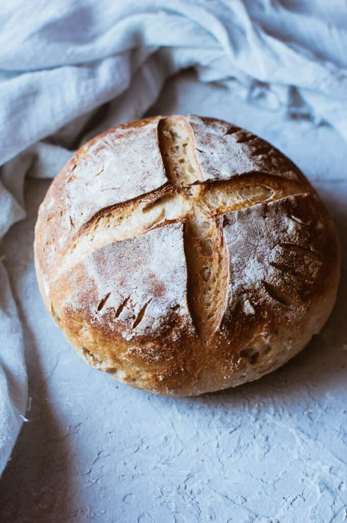 a rustic gluten free boule on a grey backdrop