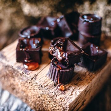 a wooden block topped with honey filled chocolates