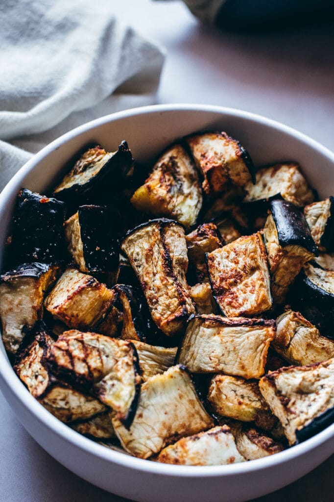 Grilled eggplant in a white bowl on a table, cooked using an air fryer.