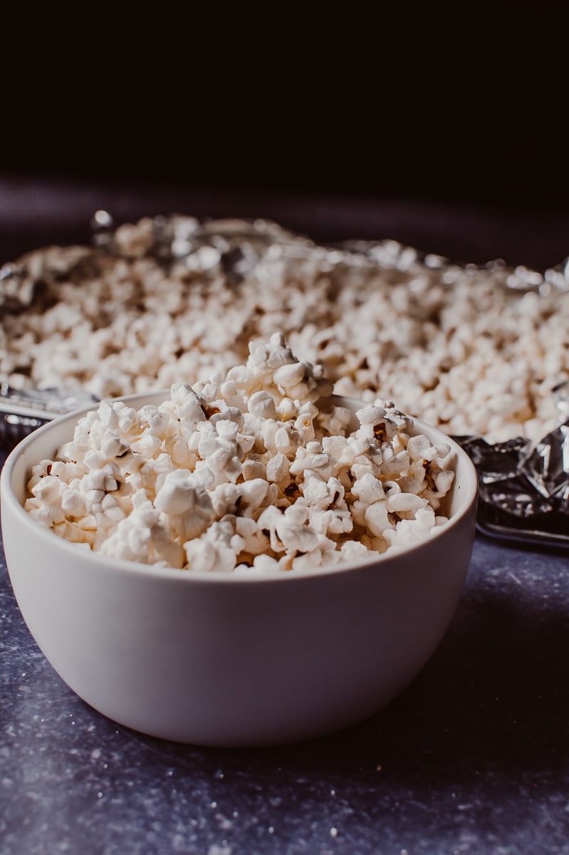 A white bowl filled with white popped corn.