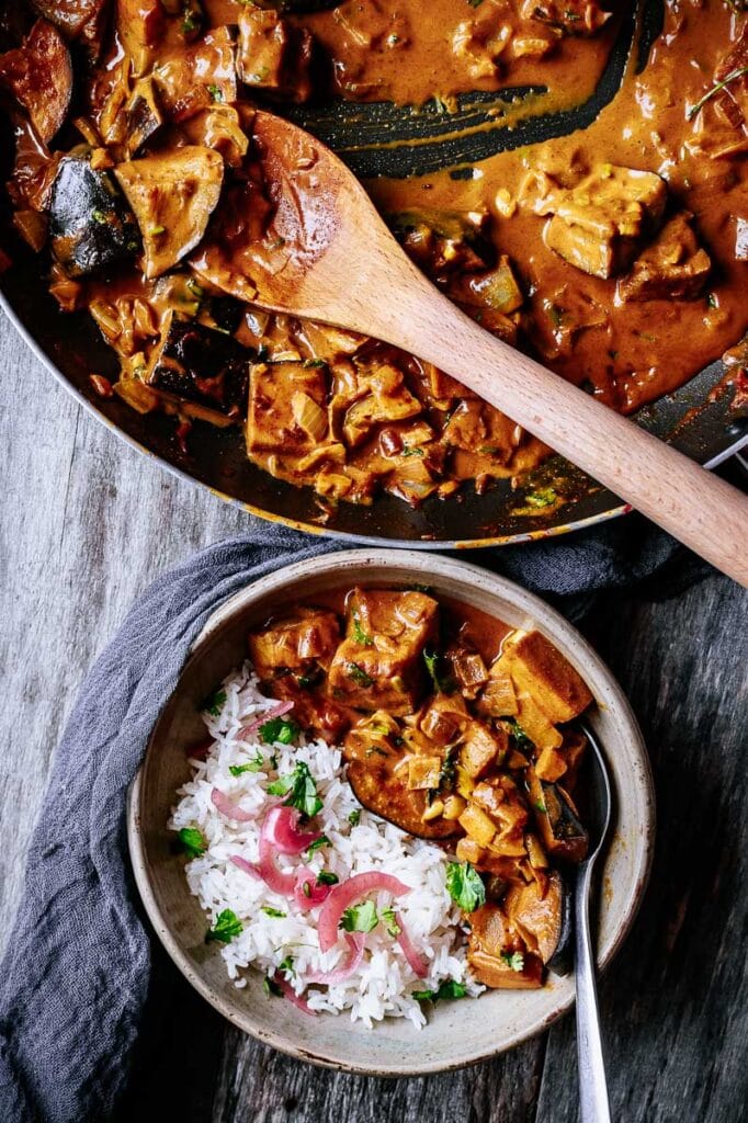 a pot and a bowl filled with curry and rice