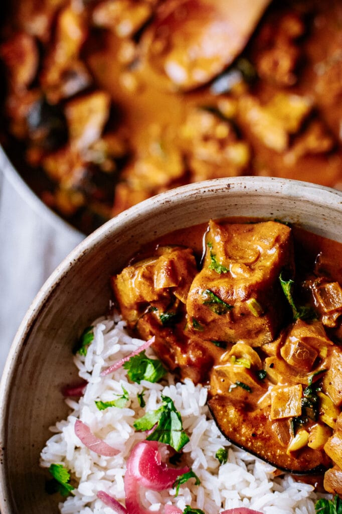 a close up macro shot of aubergine curry in a bowl