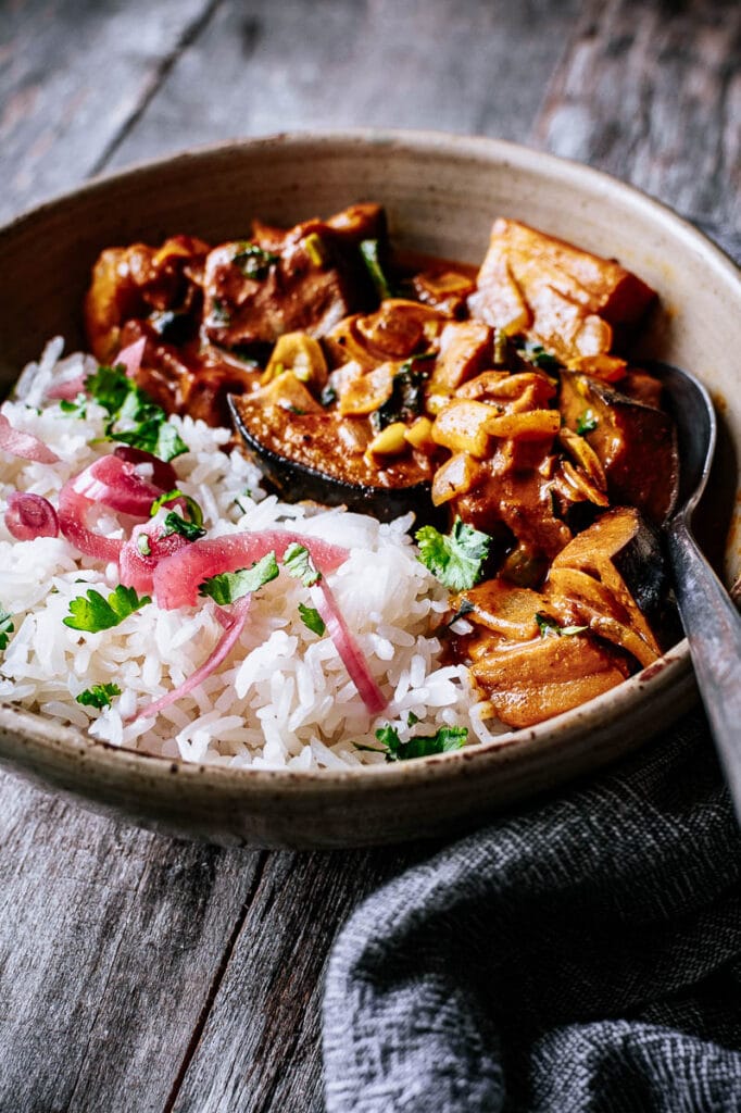 a bowl with rice, cilantro, pickled red onion and curry