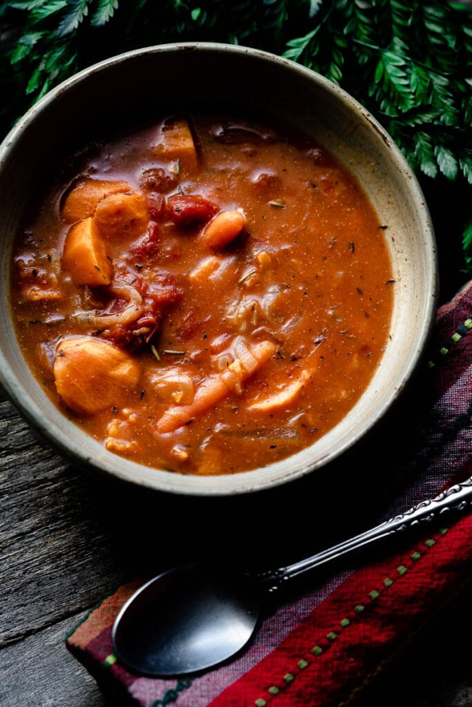 a close up of carrots in a tan bowl of stew