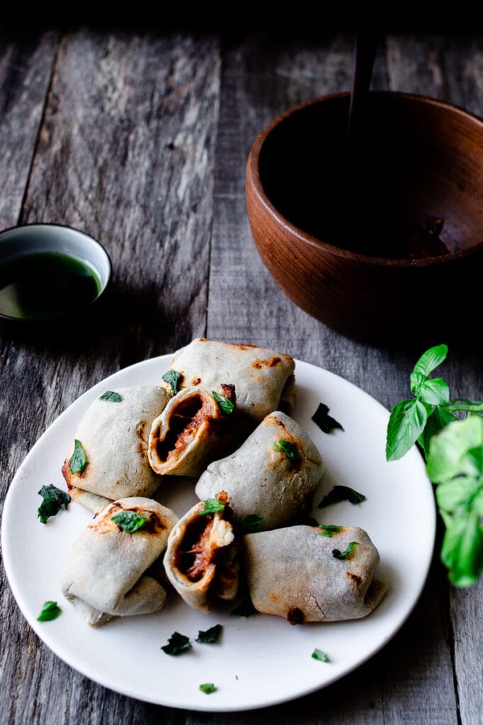 A white ceramic plate filled with white pizza rolls.