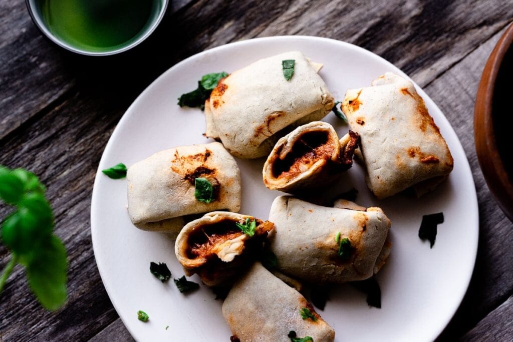 A white plate filled with homemade air fryer pizza rolls.