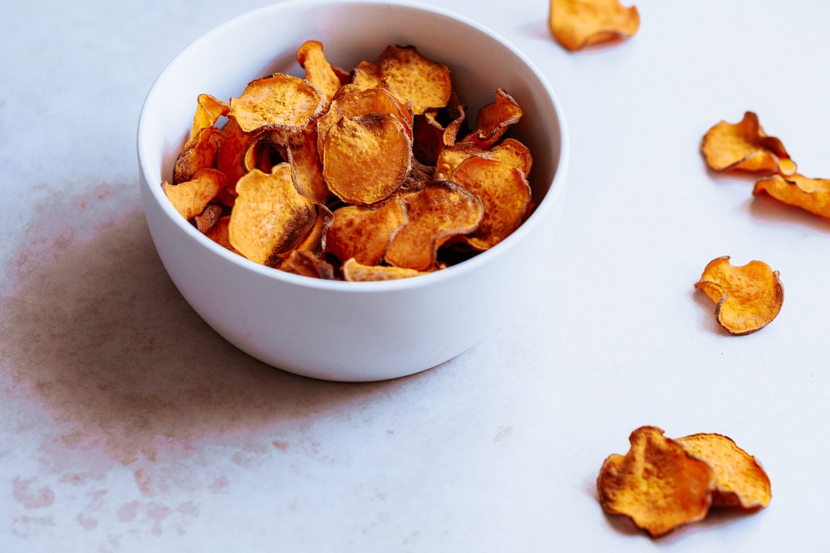 A white bowl filled with air fryer sweet potato chips.