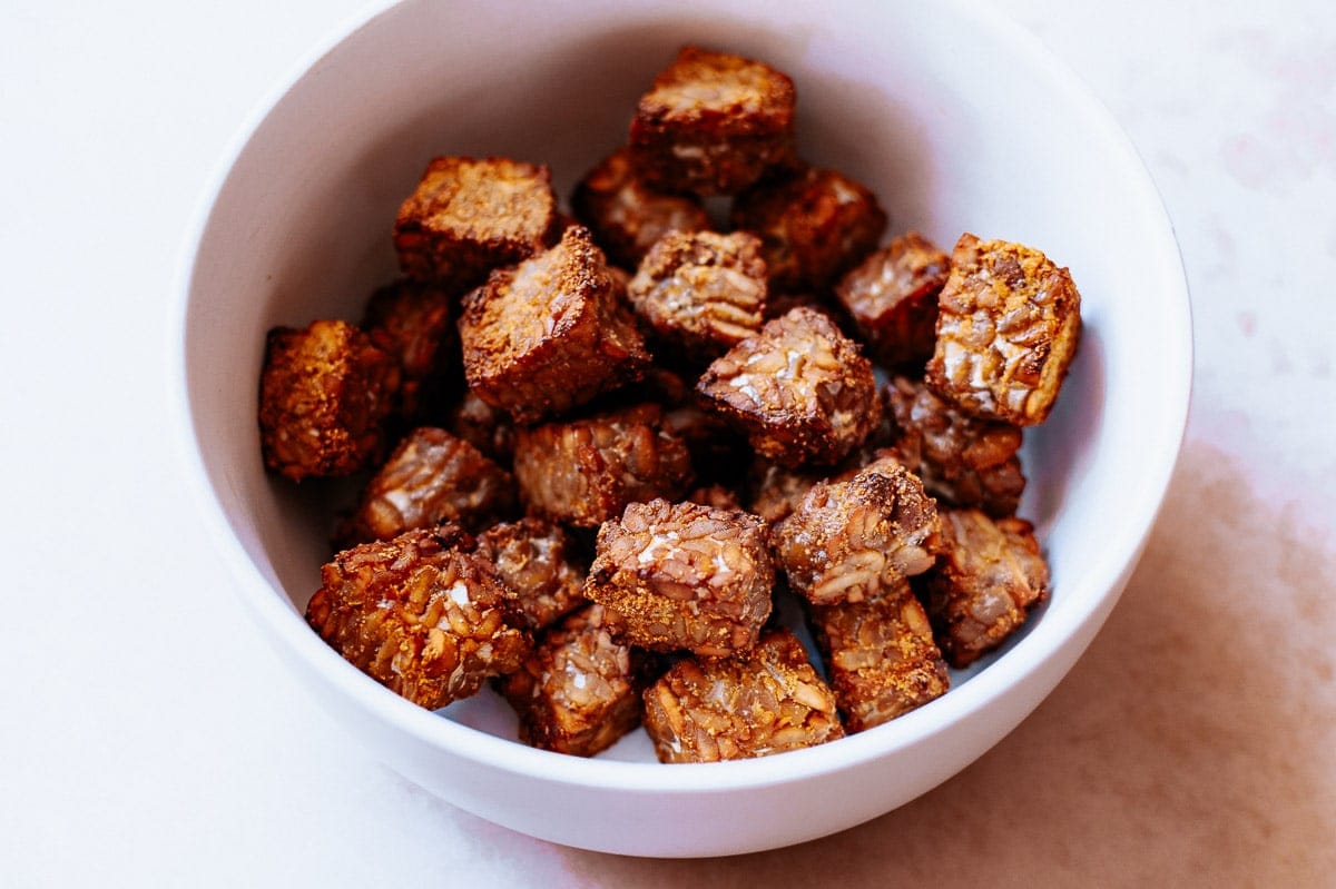 A white ceramic bowl filled with crispy tempeh.