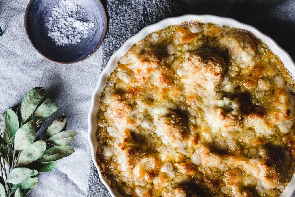 A fully cooked golden and cheesy gluten free cauliflower cheese.