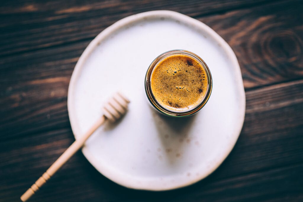 A top view of an open jar of honey alternative.