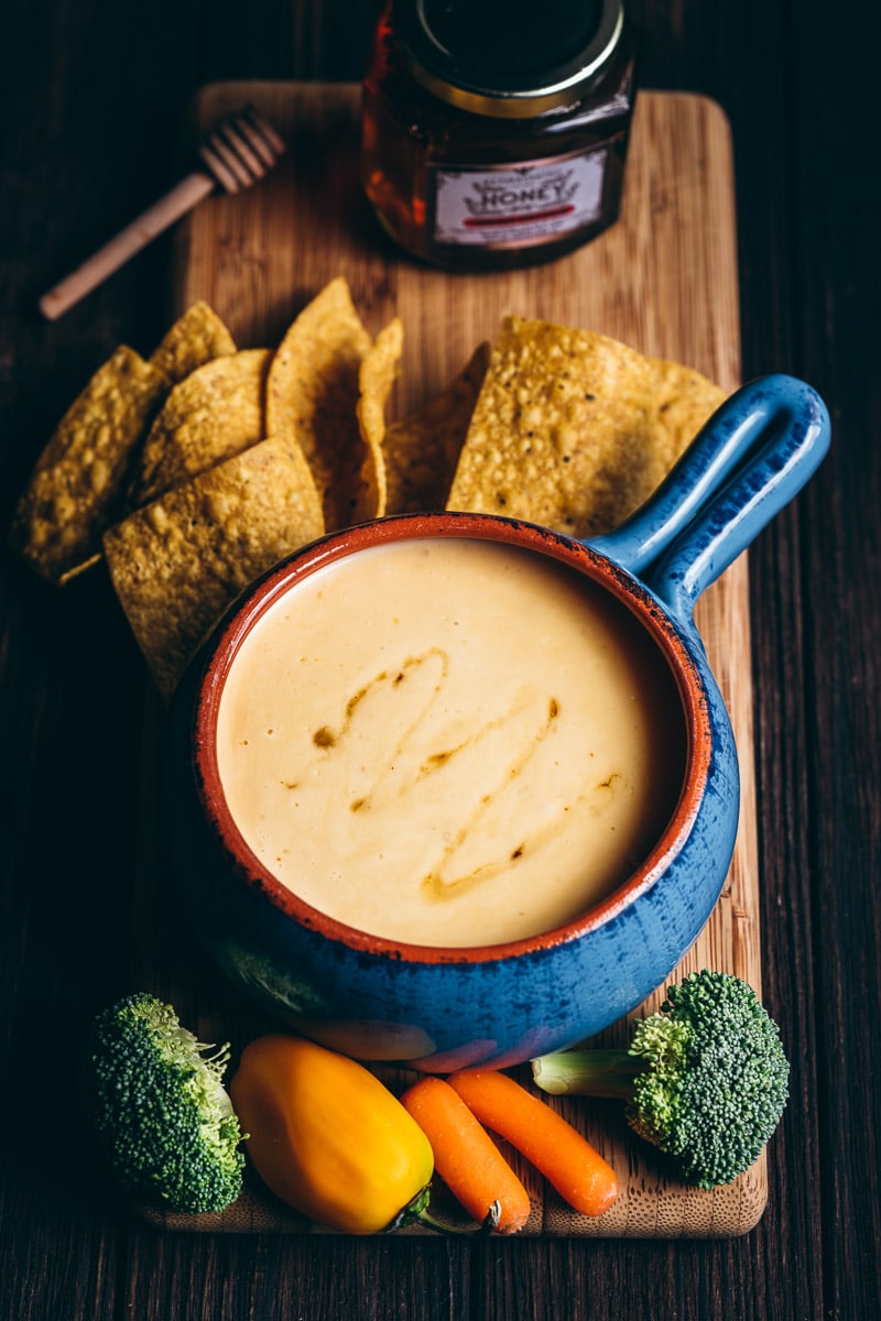 a top view of a blue crock filled with creamy spicy cheese dip