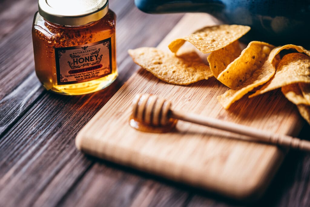 the sun lights a jar of naturacentric ghost pepper infused raw honey