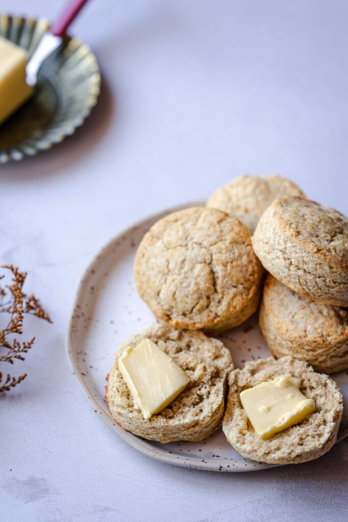 a stack of fluffy gluten free buttermilk biscuits rest on a white plate