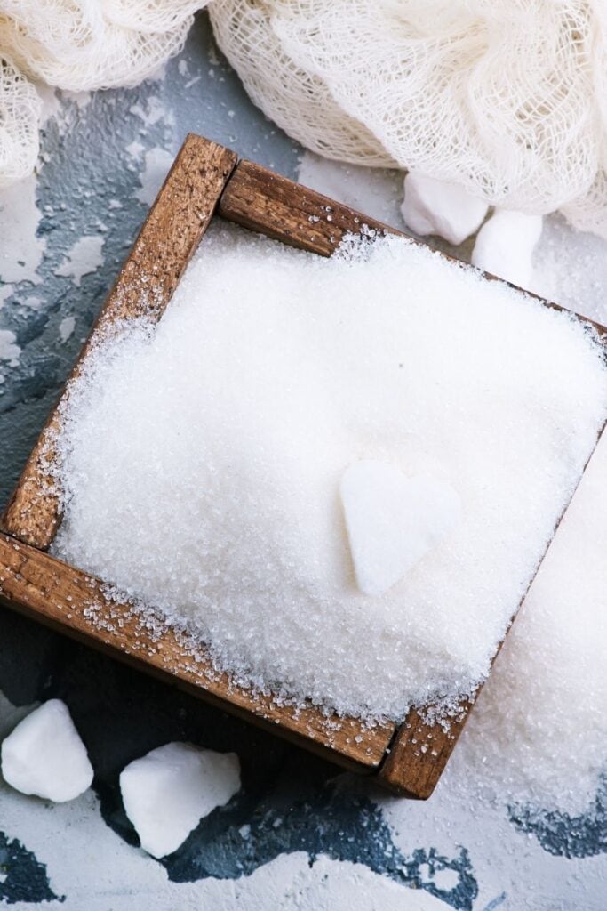 a wooden box spilling over with fresh white cane sugar