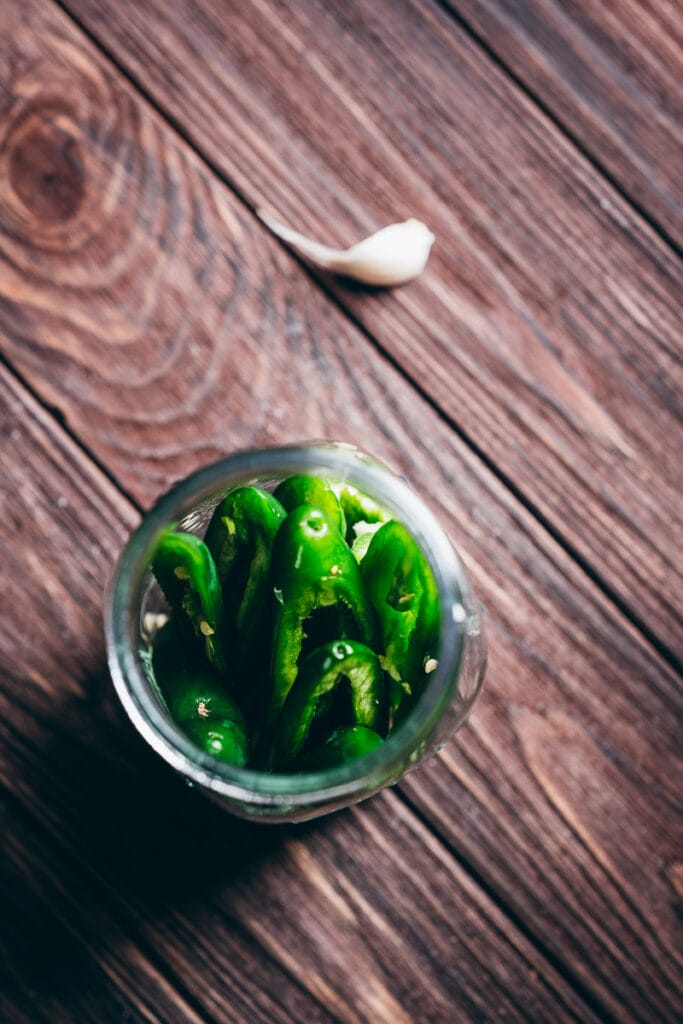 a jar stuffed with bright green jalapeno peppers