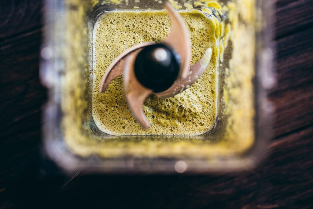 a blender filled with frothy bubbly fermented jalapeno hot sauce