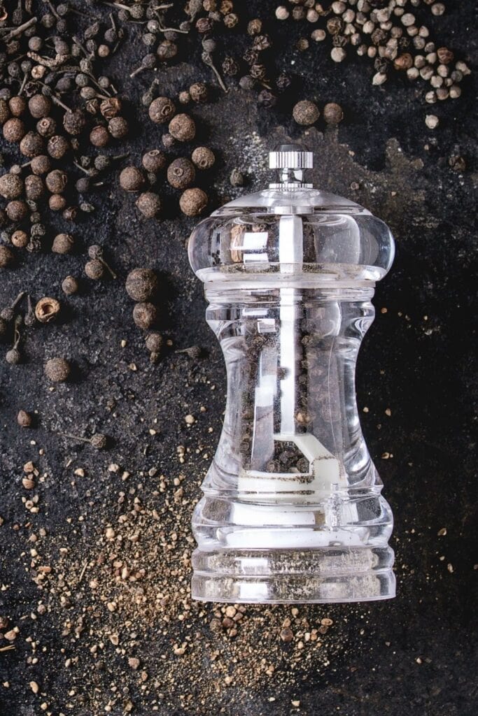 a pepper grinder filled with black peppercorns ground as a turmeric alternative