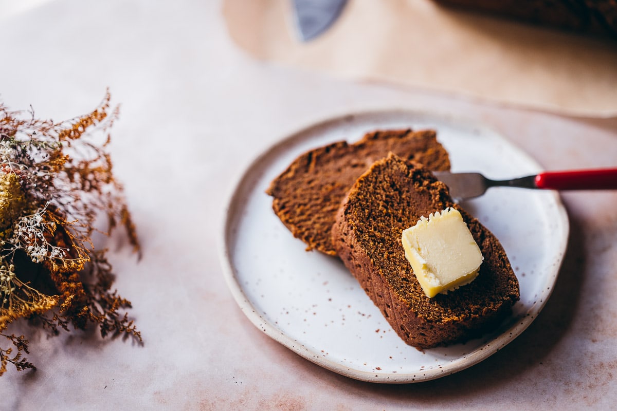 slices of gluten free pumpkin bread resting on a speckled ceramic plate