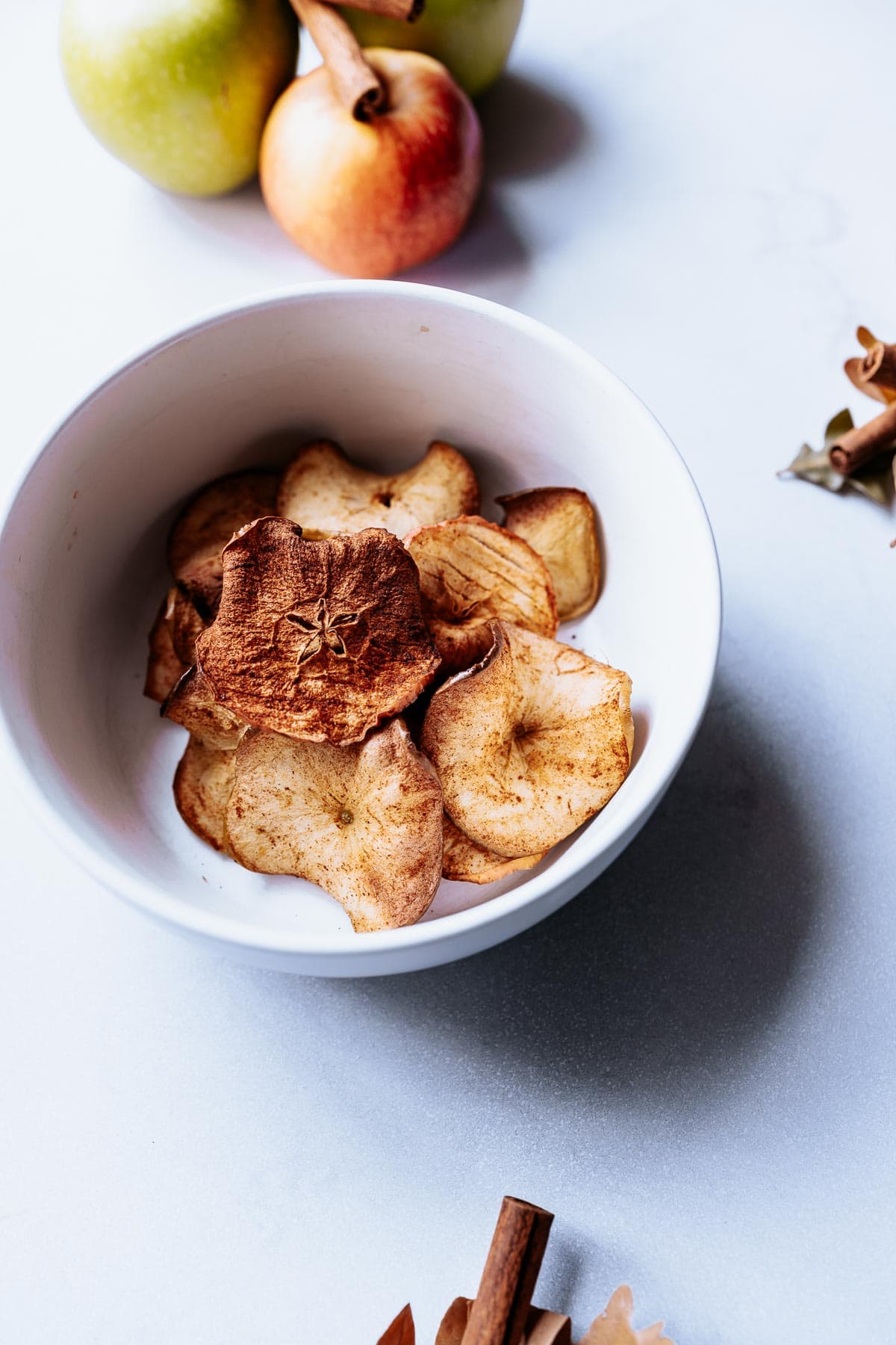 a white bowl of homemade cinnamon air fryer apple chips