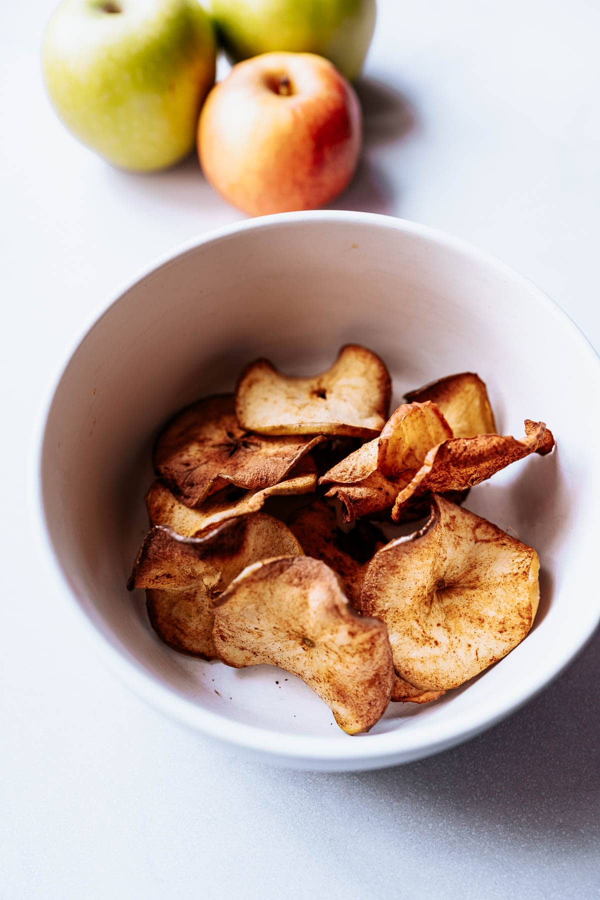 a white bowl of cinnamon sugar air fryer apple chips