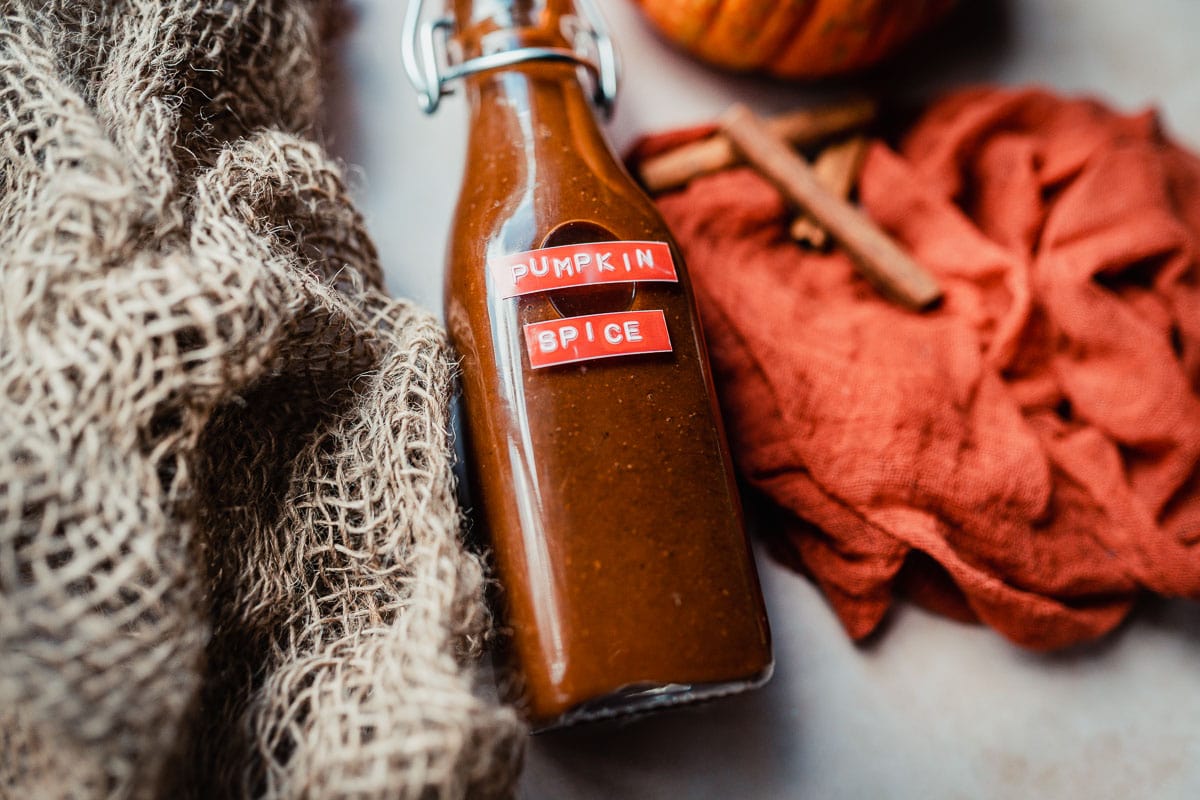 a small bottle filled with orange pumpkin spice syrup