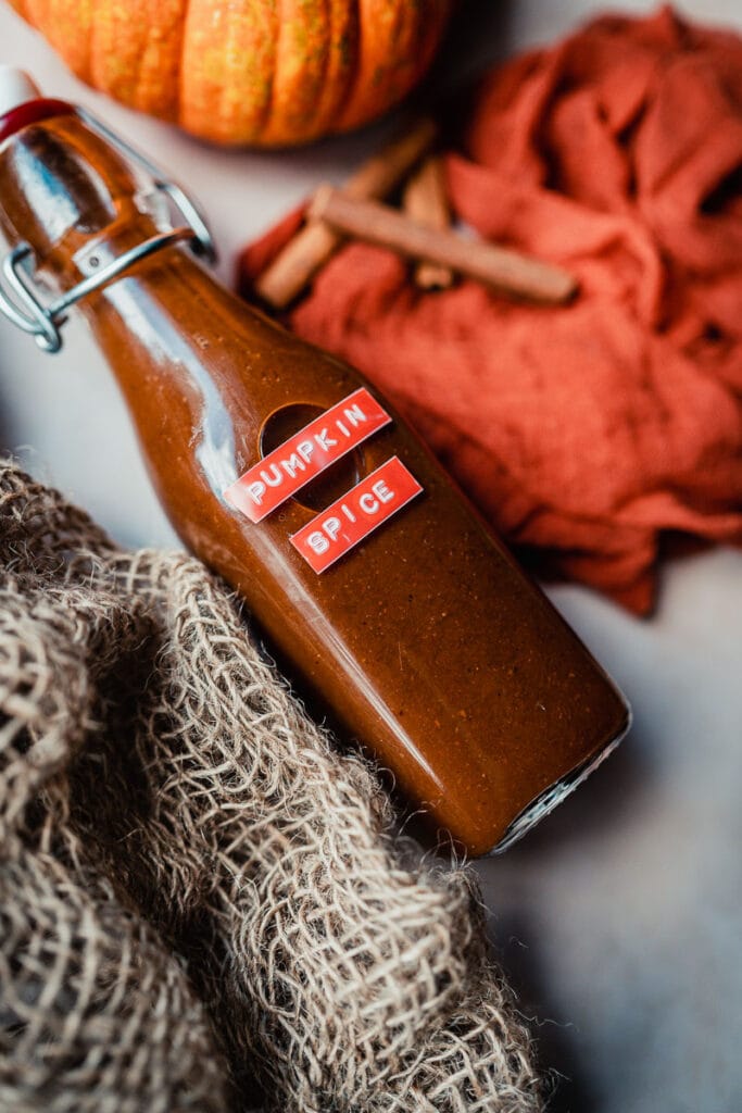 a bottle of pumpkin spice syrup resting on a piece 