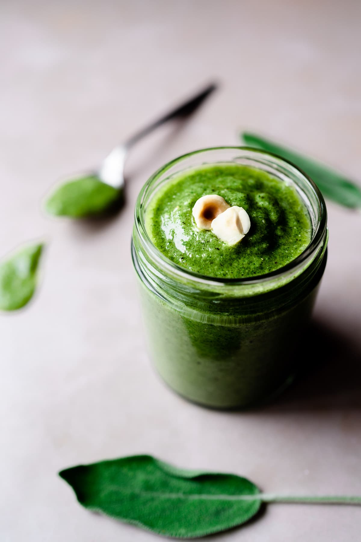 a clear jar packed with the brim with hazelnut sage pesto